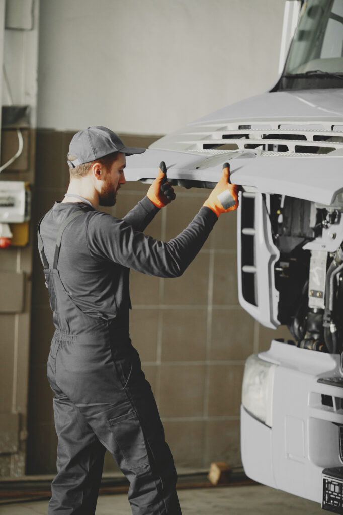 Mechanic opening the hood of a truck.